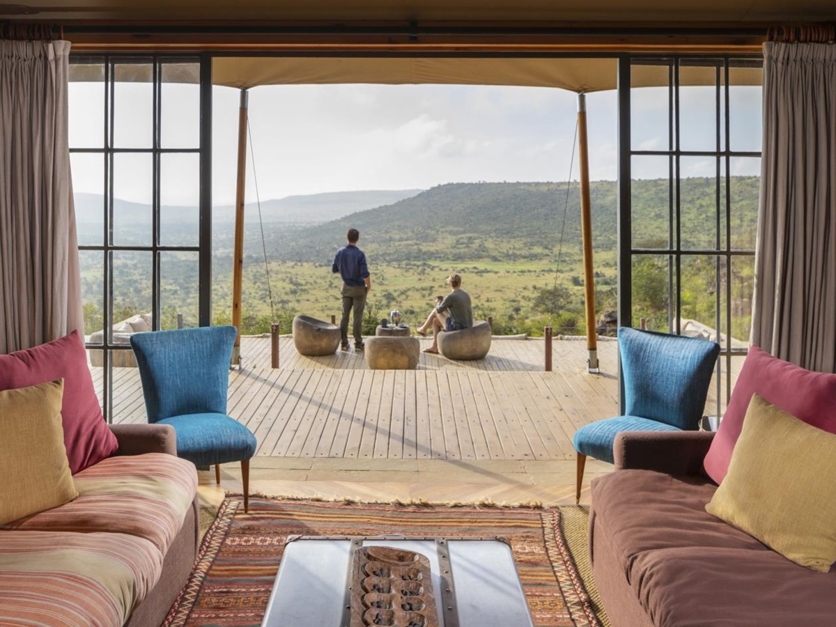 two guests enjoying the view from the main deck outside the lounge at luxury safari lodge Lodo Springs in the Laikipia region of Kenya
