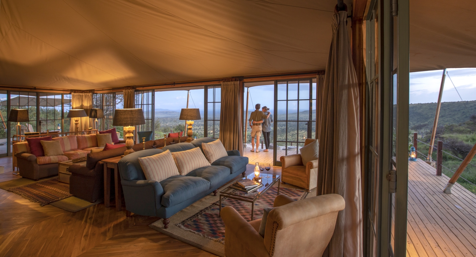 Two guests on the verandah outside the lounge area at luxury safari lodge Lodo Springs in the Laikipia region of Kenya