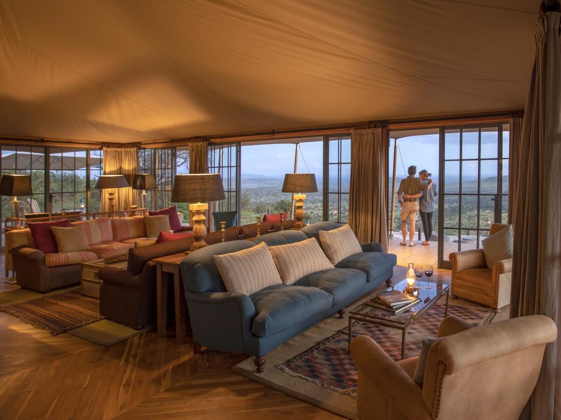 Two guests on the verandah outside the lounge area at luxury safari lodge Lodo Springs in the Laikipia region of Kenya