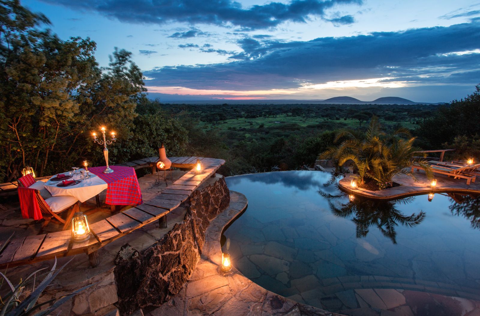 Private candlelit dinner setup by the pool at luxury lodge Ol Donyo in Kenya