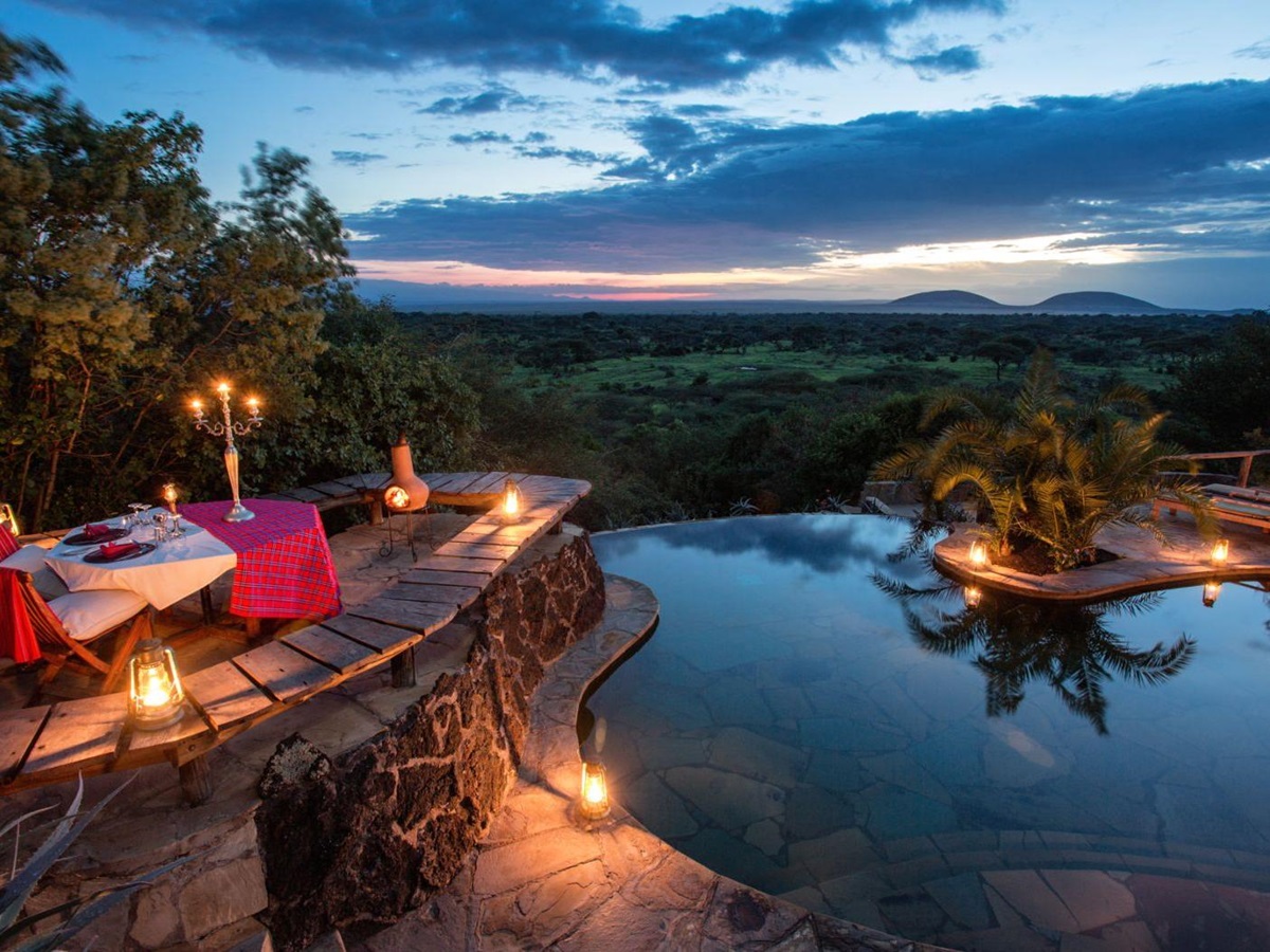 Private candlelit dinner setup by the pool at luxury lodge Ol Donyo in Kenya