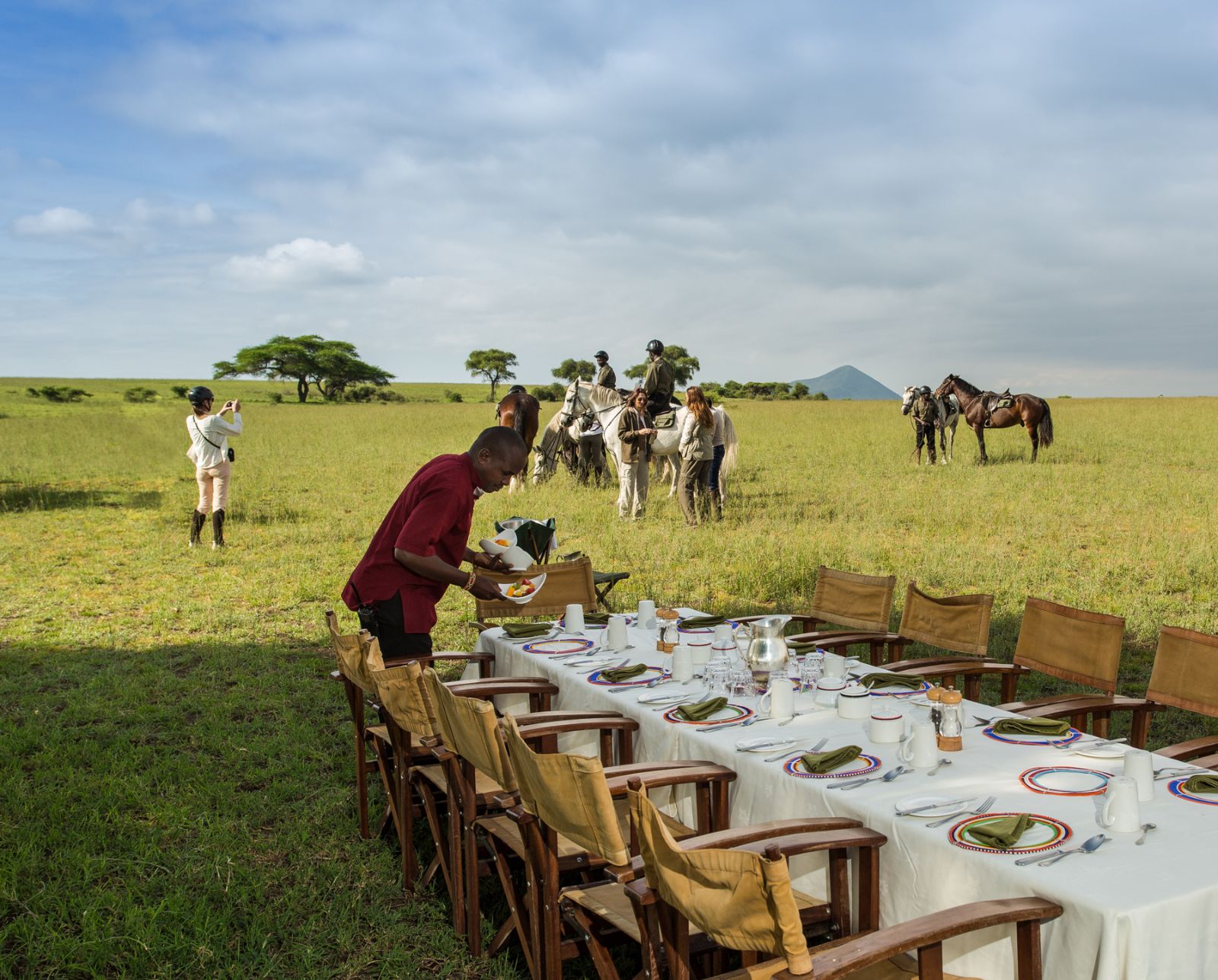 Guests arriving at a bush breakfast after a morning ride during a stay at luxury lodge Ol Donyo in Kenya