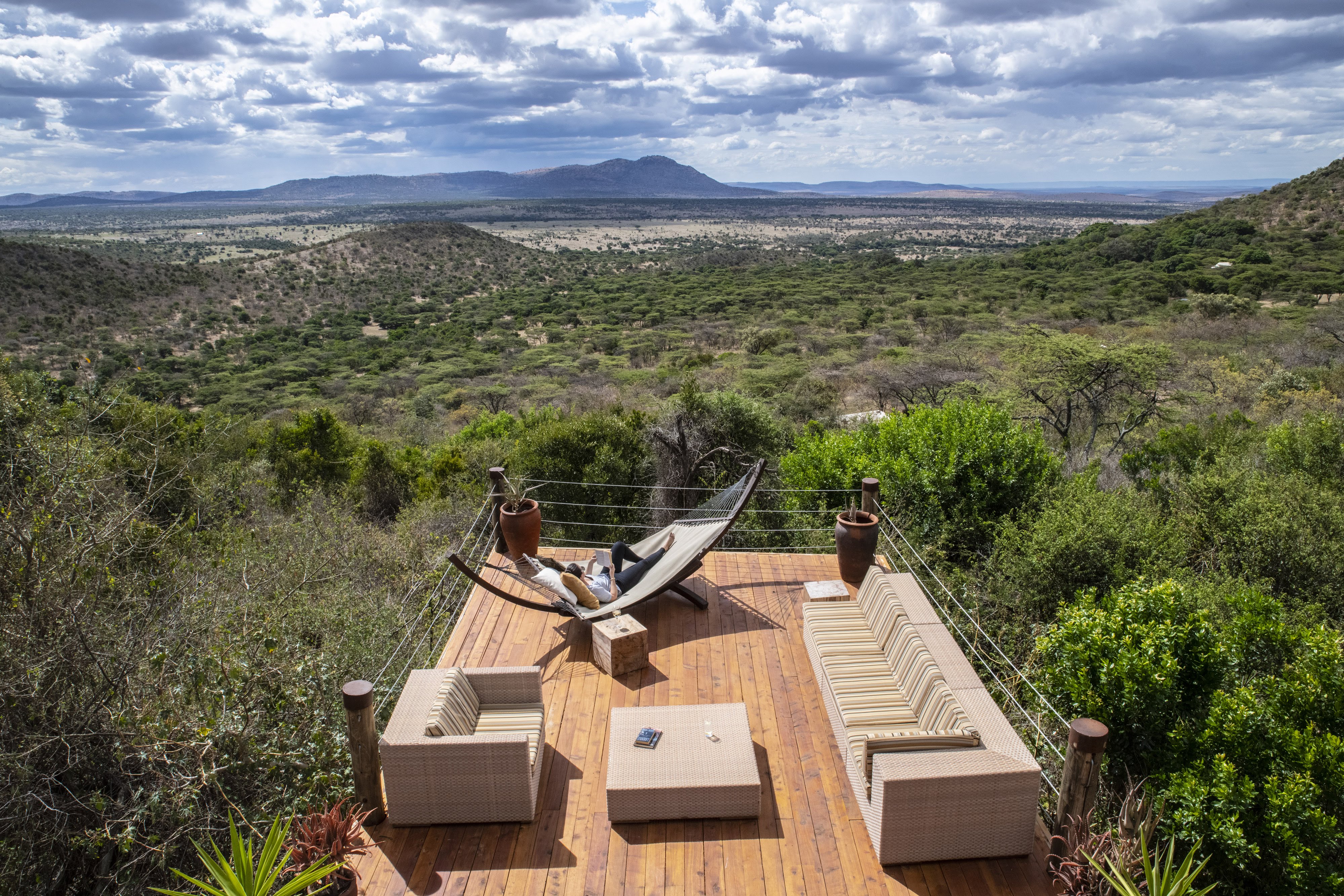 Guest at Cottars Bush Villa in Kenya reclined in hammock on lower deck