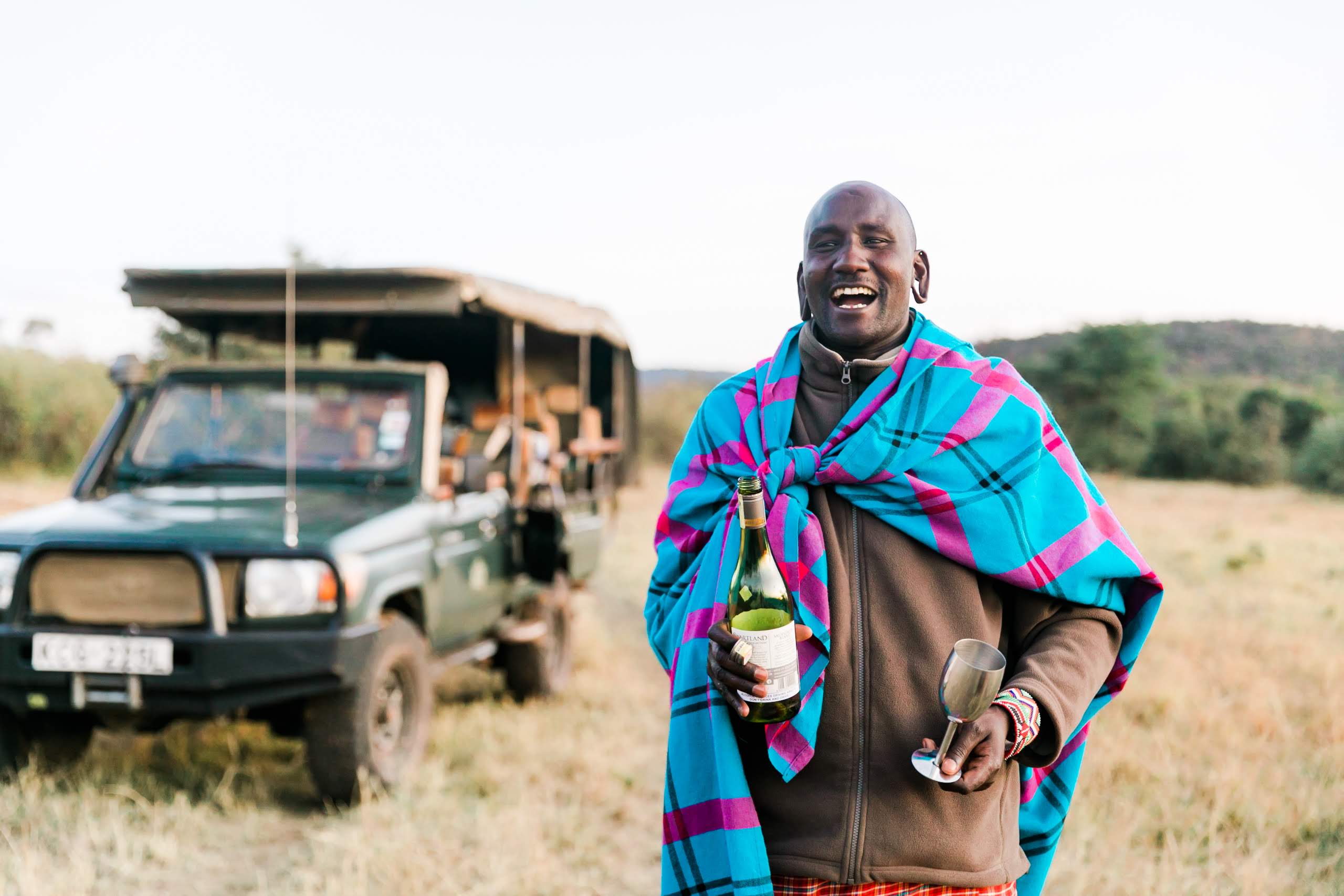 A local guide serving wine on a game drive from Cottars camp in Kenya