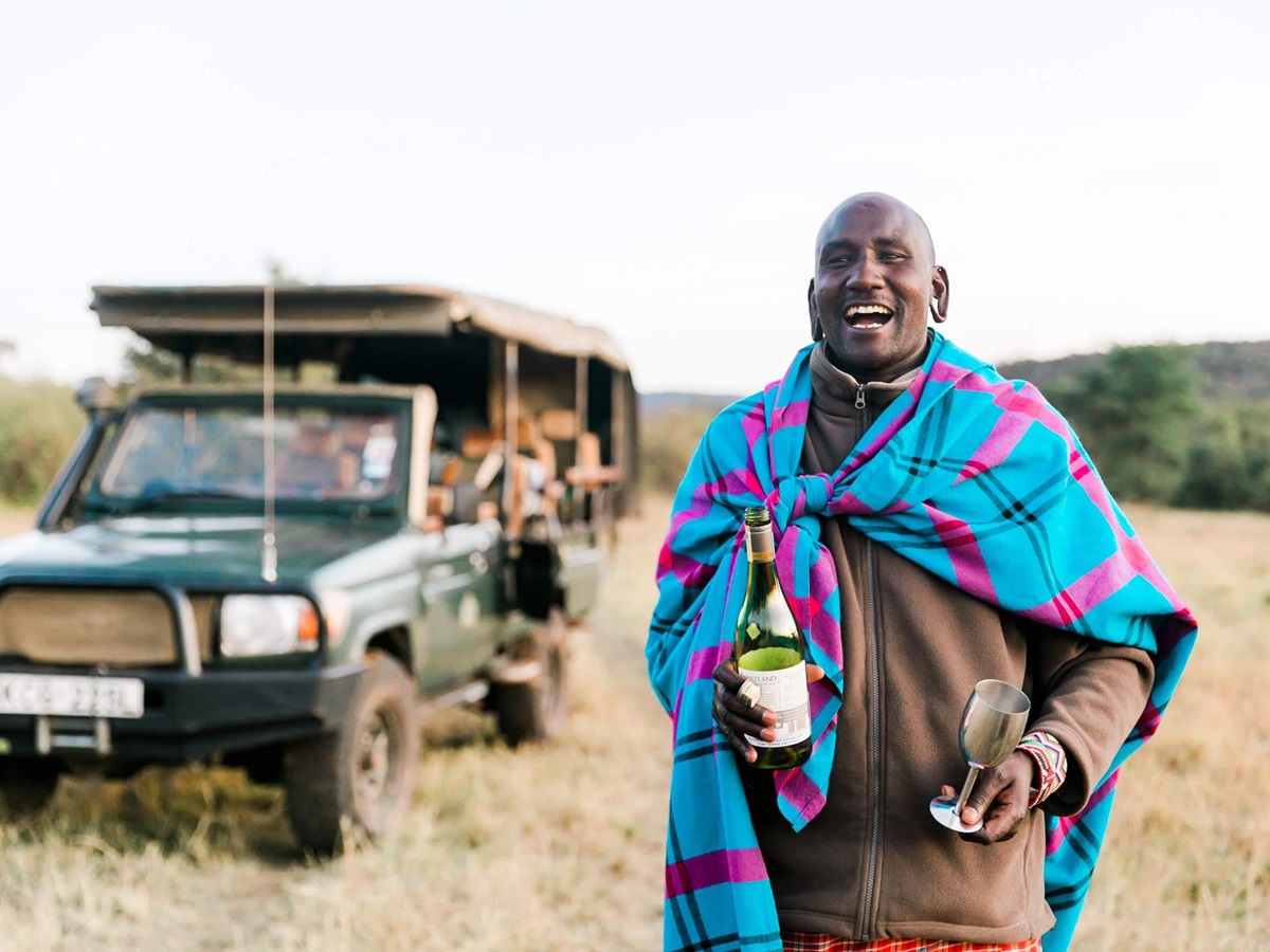 A local guide serving wine on a game drive from Cottars camp in Kenya