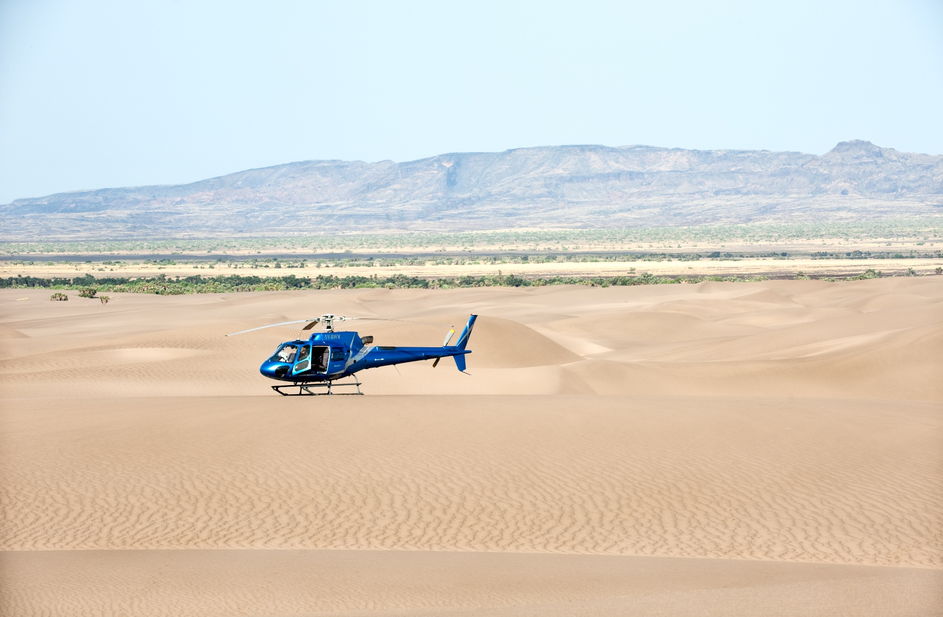 A helicopter flying over the Kenyan desert