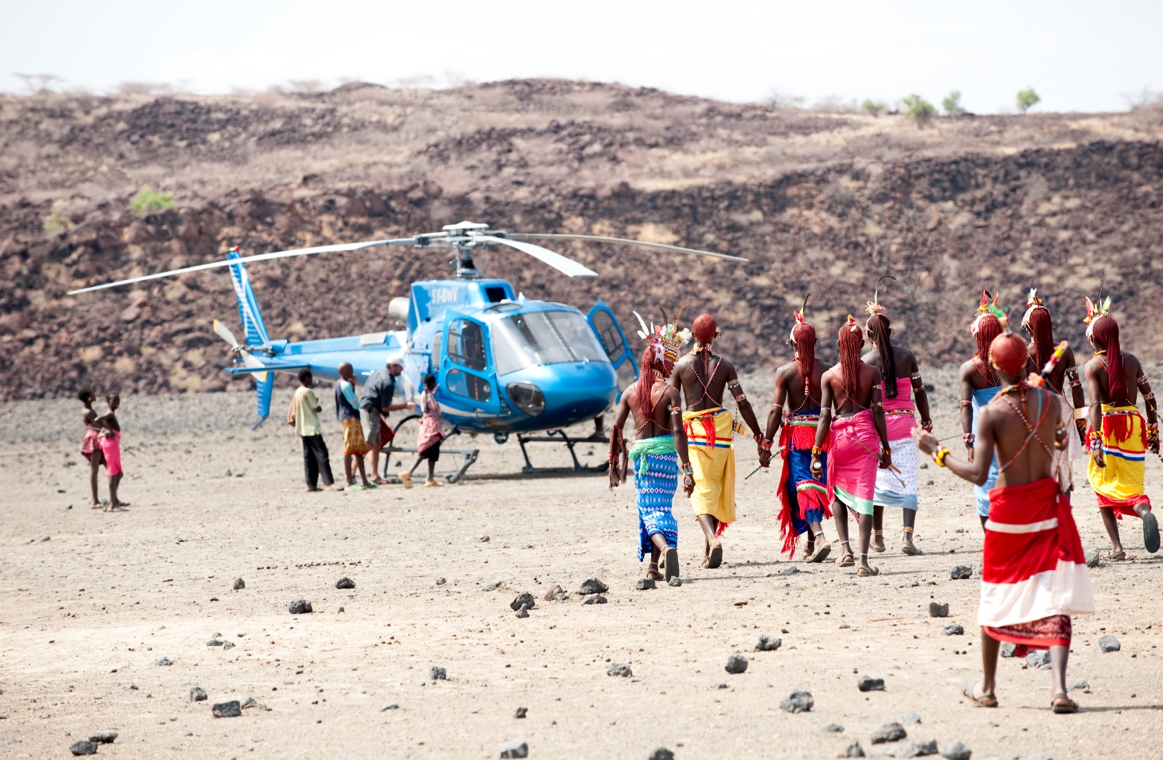 Kenyans coming to greet a visiting helicopter
