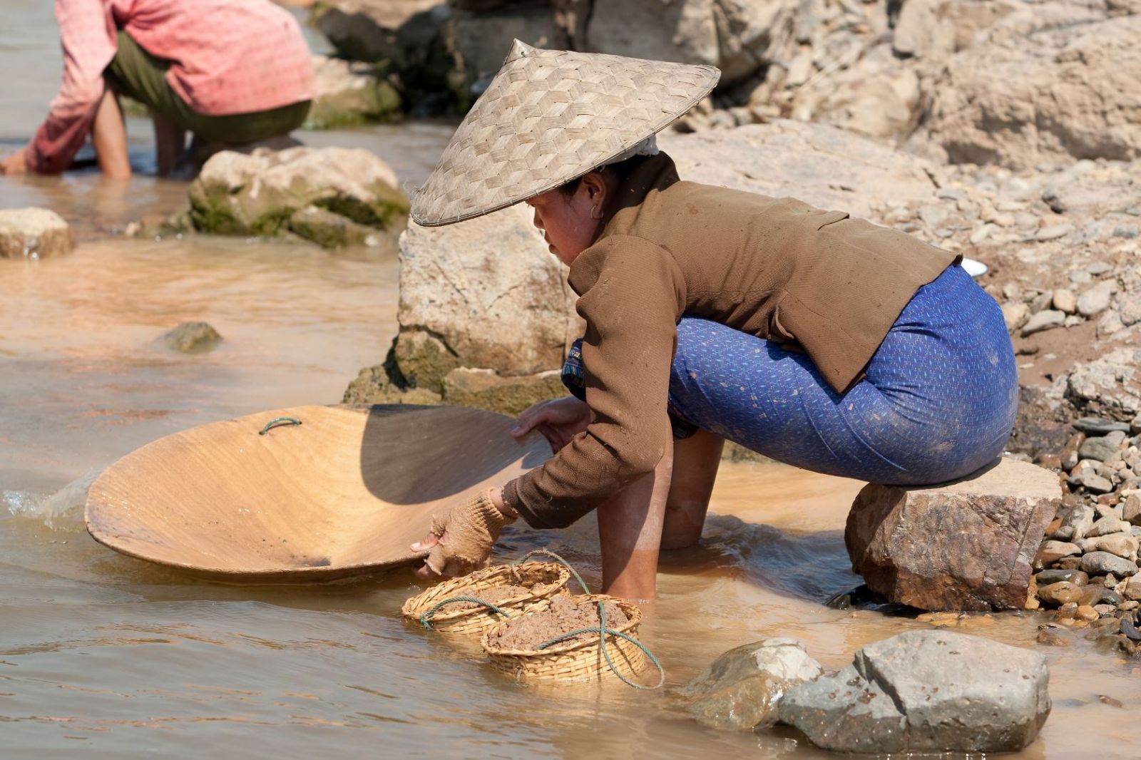Woman panning for gold in Laos