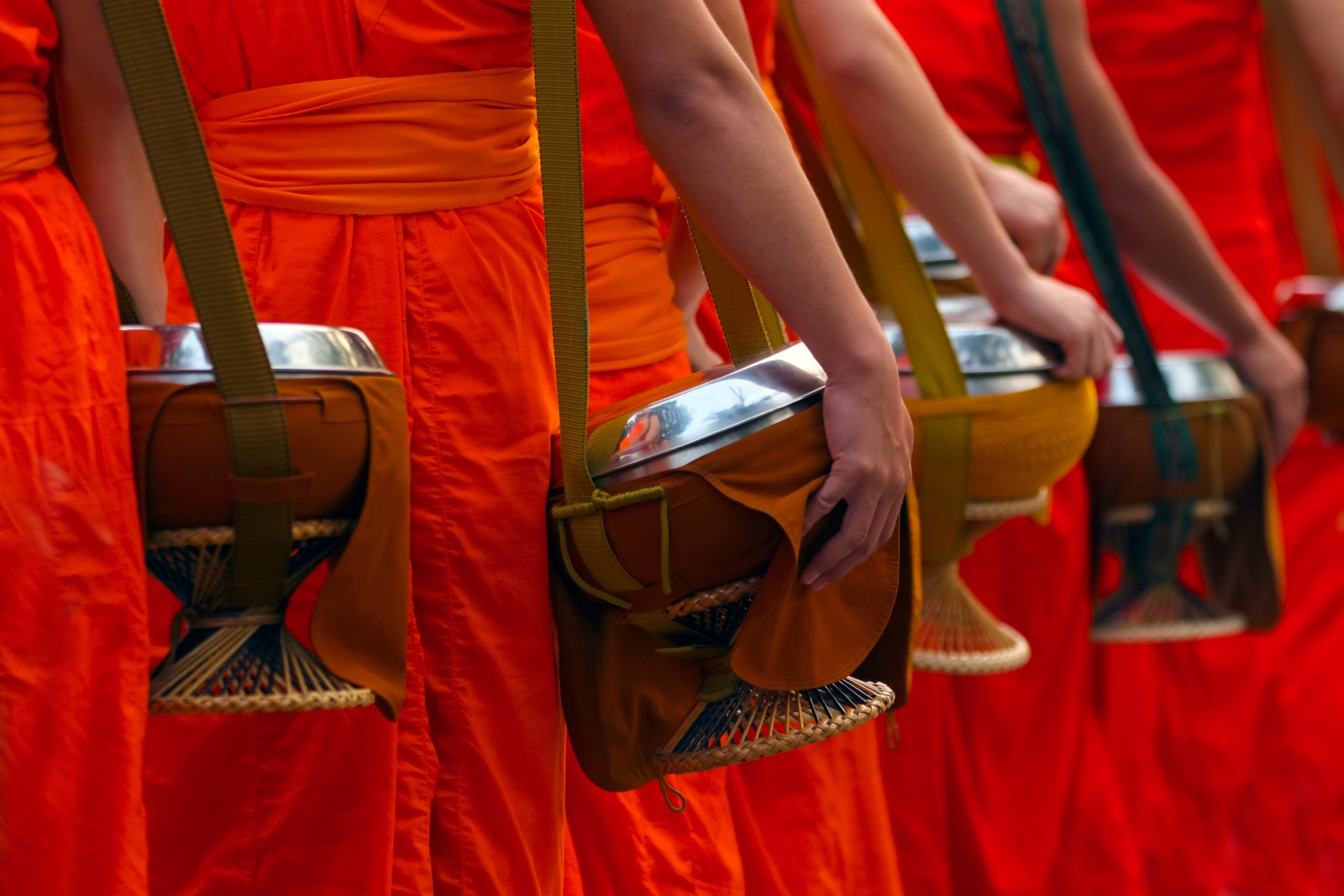 Buddhist monks walk with bowls