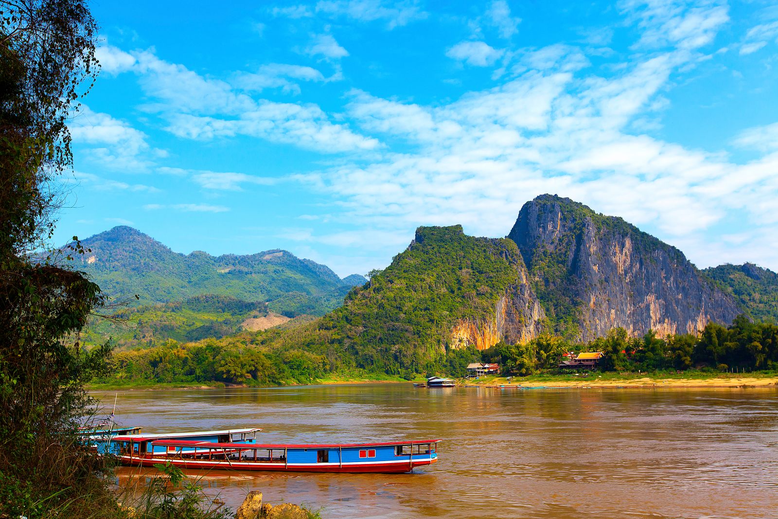 A brightly painted boat crusing down the Mekong in Laos