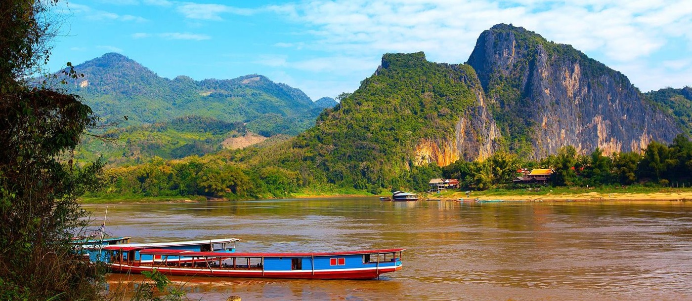 A brightly painted boat crusing down the Mekong in Laos