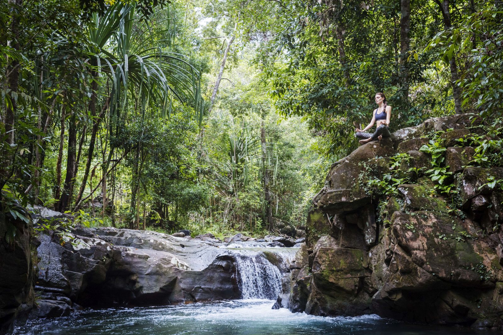 Guest practising meditation by a jungle stream at the Datai Langkawi in Malaysia