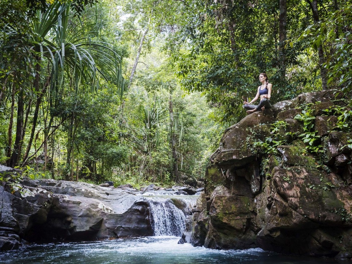 Guest practising meditation by a jungle stream at the Datai Langkawi in Malaysia