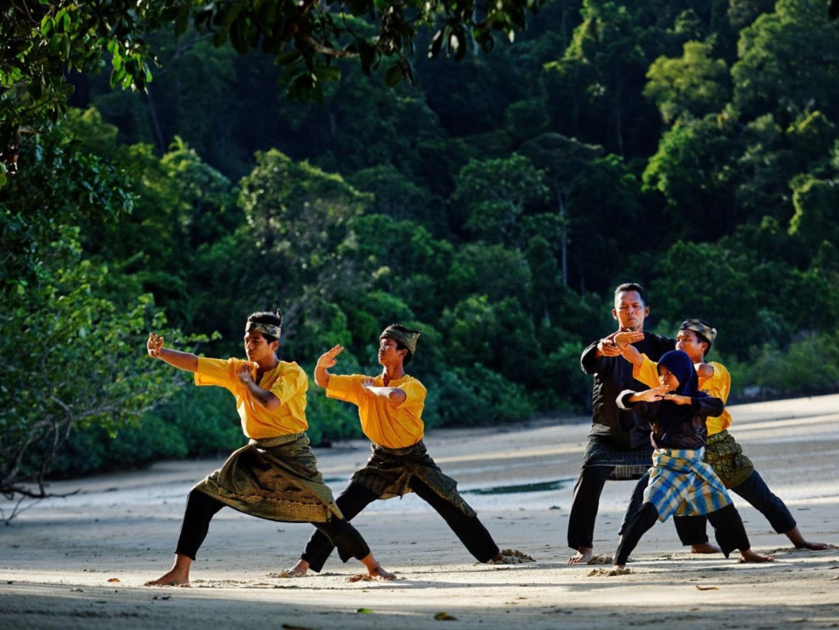 A group performing Silat on the beach at luxury resort The Datai