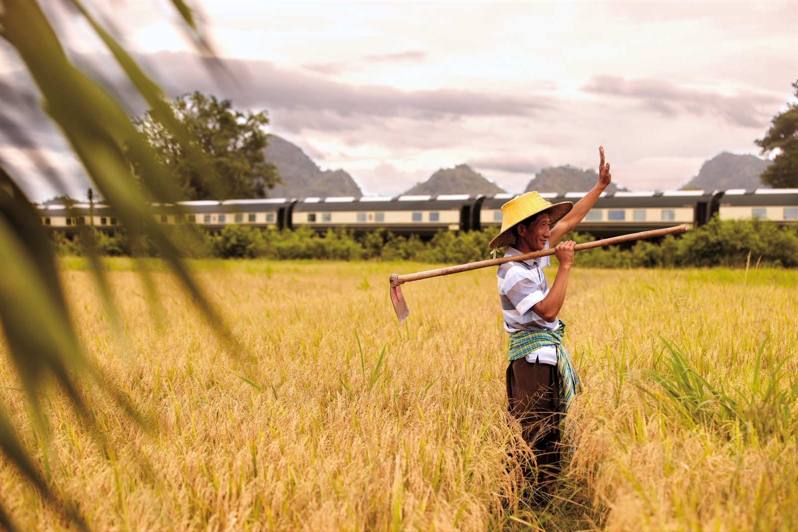 Local farmer waving at the Eastern & Oriental Express