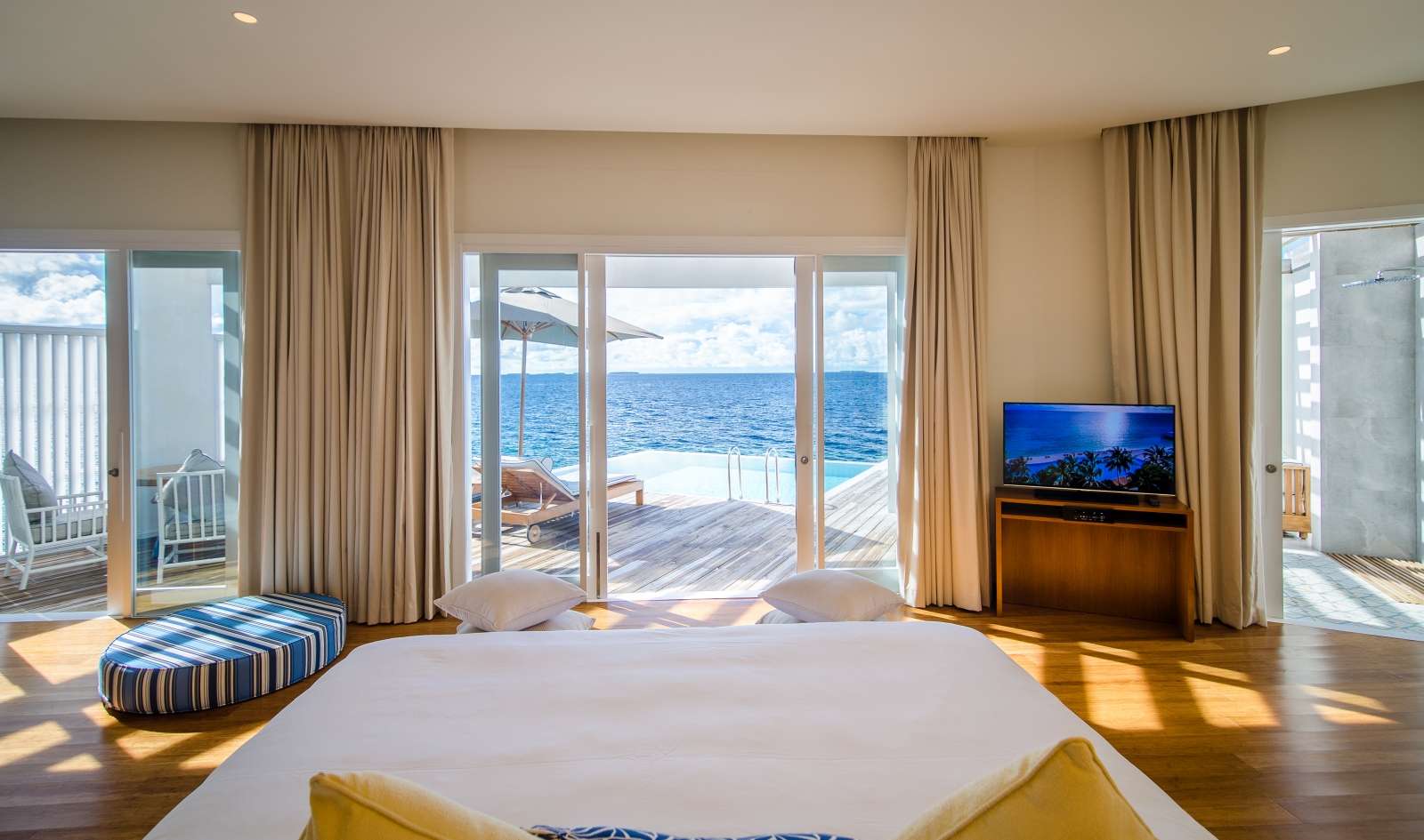 Interior of an Ocean Reef House with double bed and private terrace at luxury resort Amilla in the Maldives
