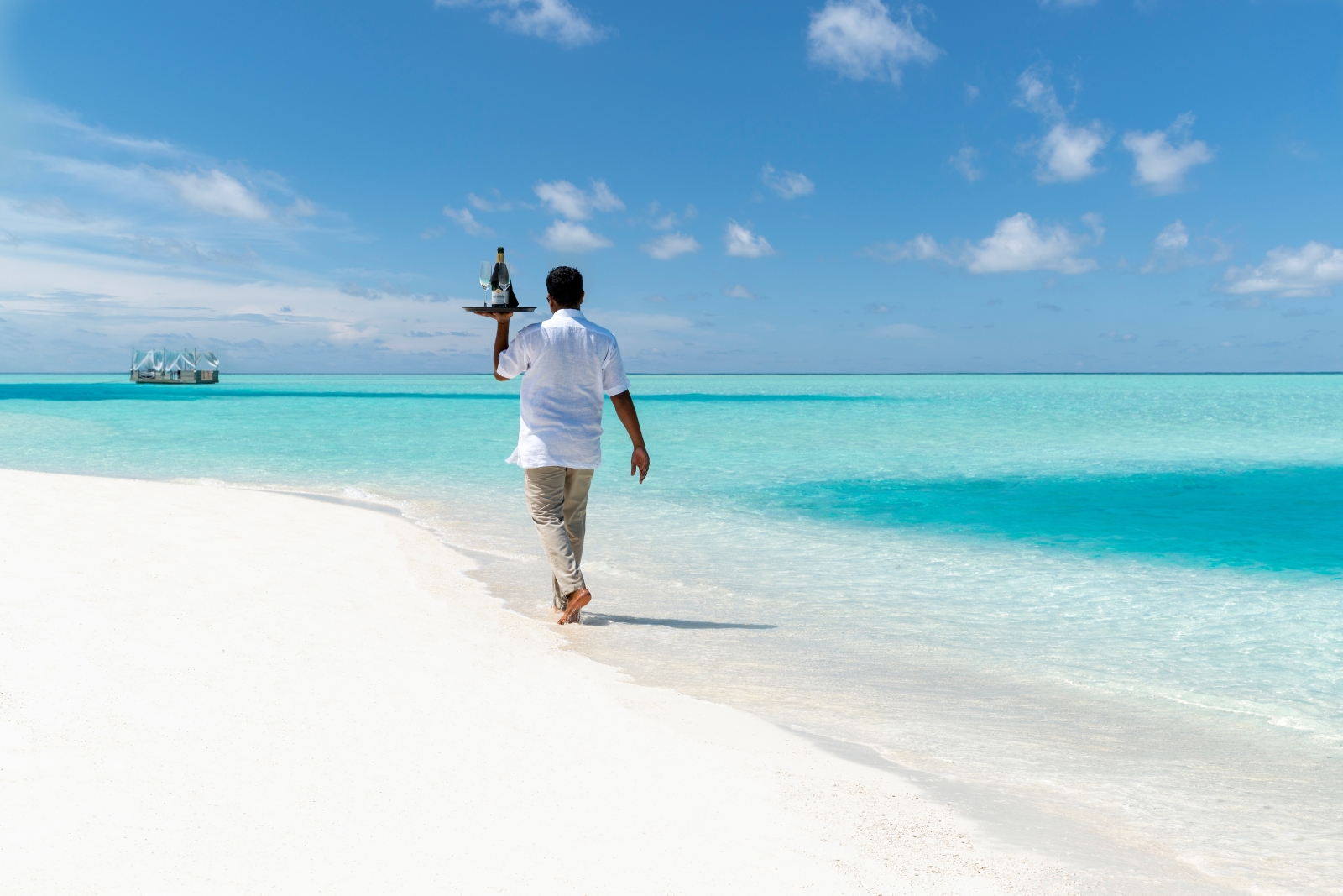 Butler serving drinks on the beach at luxury resort Anantara Dhigu in the Maldives