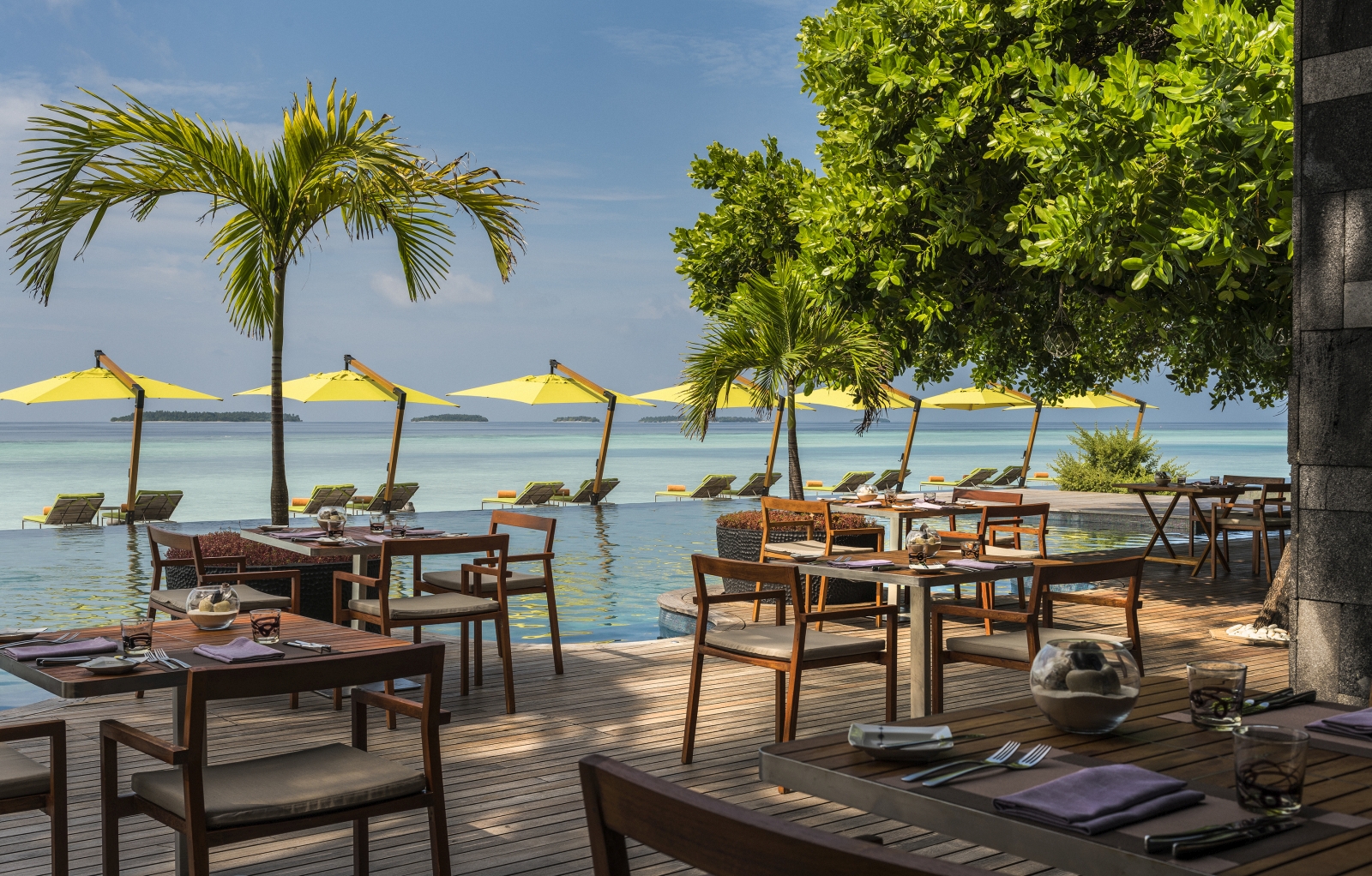 Pool-side dining overlooking the Indian Ocean at Manzaru restaurant at luxury resort Anantara Kihavah in the Maldives