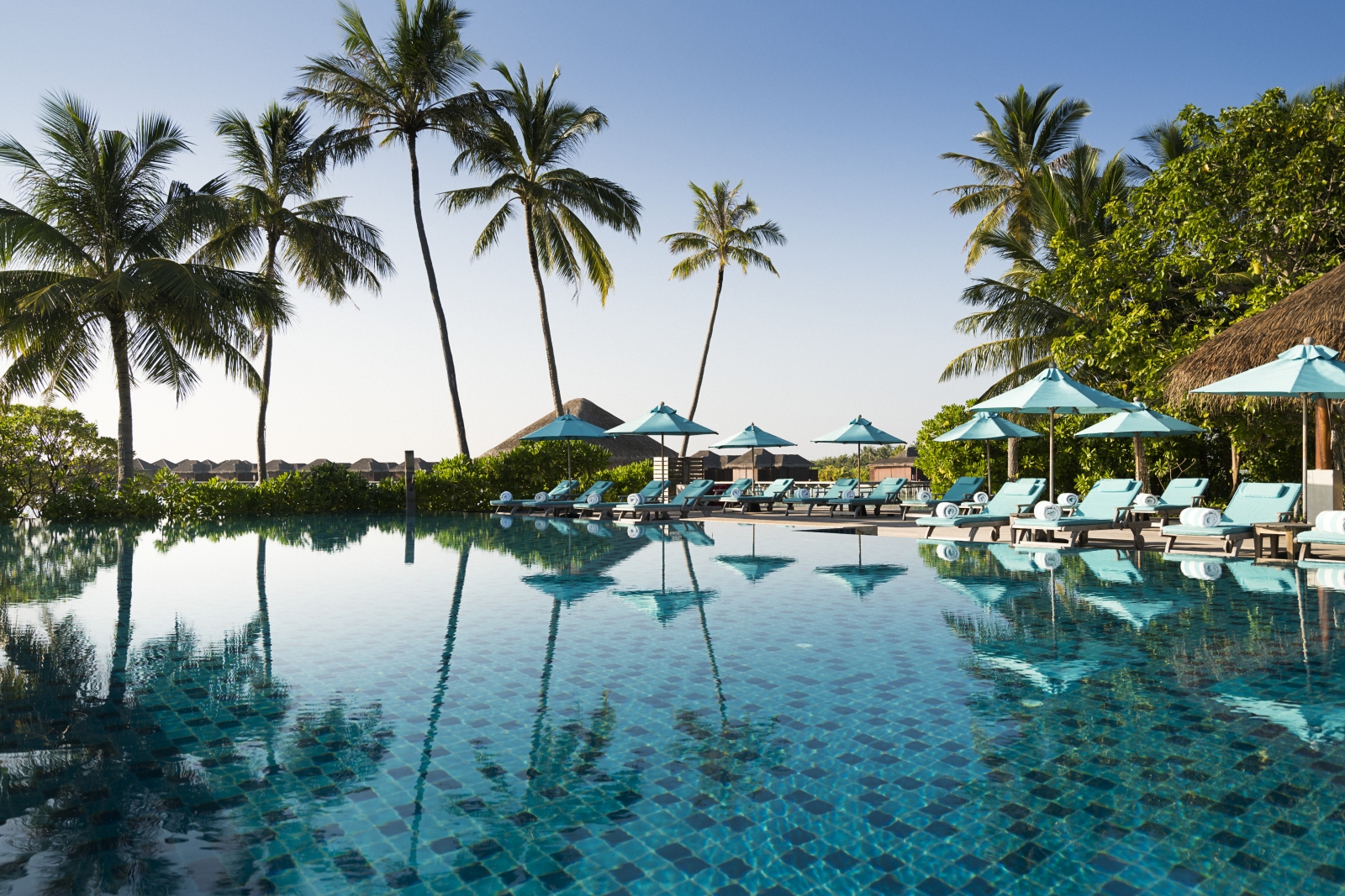 Main pool with loungers and parasols at luxury resort Anantara Veli in the Maldives