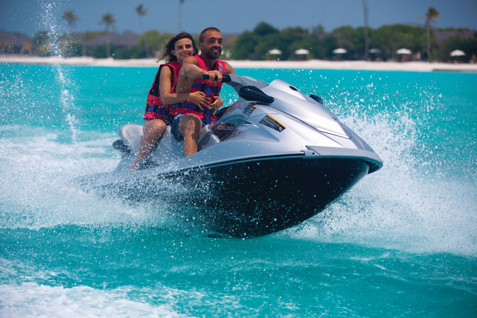 Two guests enjoying a jet ski ride at luxury resort Atmosphere Kanifushi in the Maldives