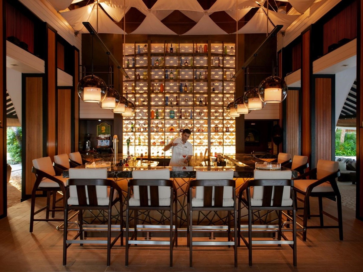 Bar seating and barman at Sails Bar at Baros