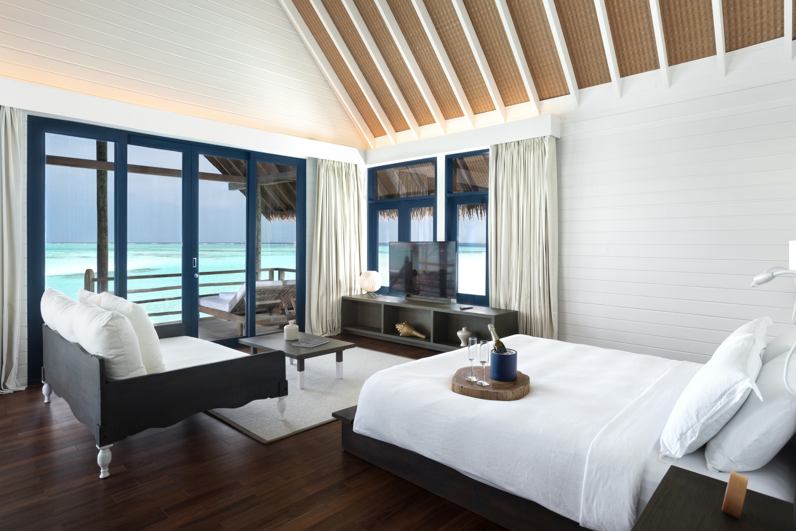 Double bedroom with private deck of a Water Villa at luxury resort Cocoa Island in the Maldives