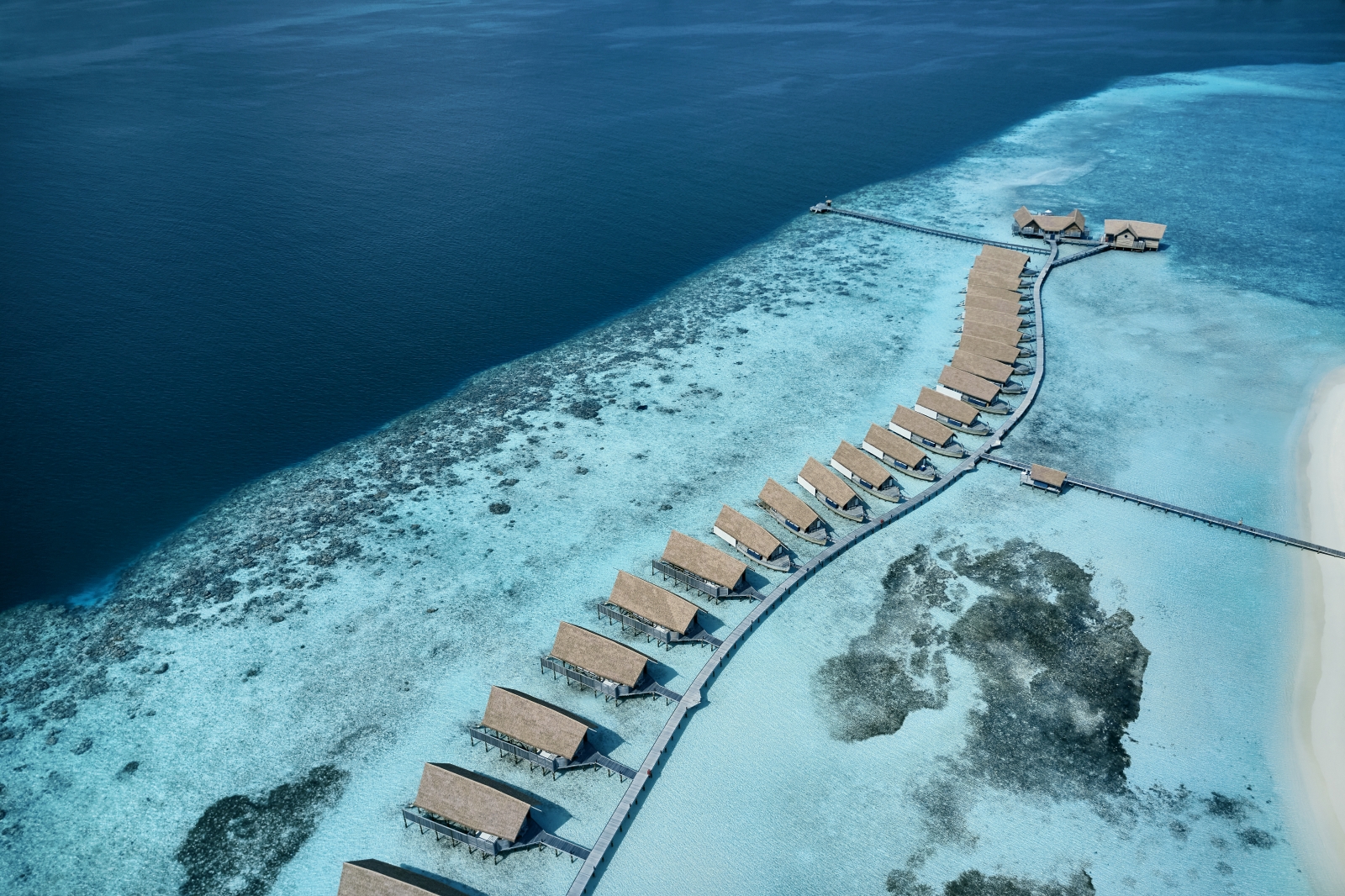 Aerial view of the jetty and Water Villas at luxury resort Cocoa Island in the Maldives