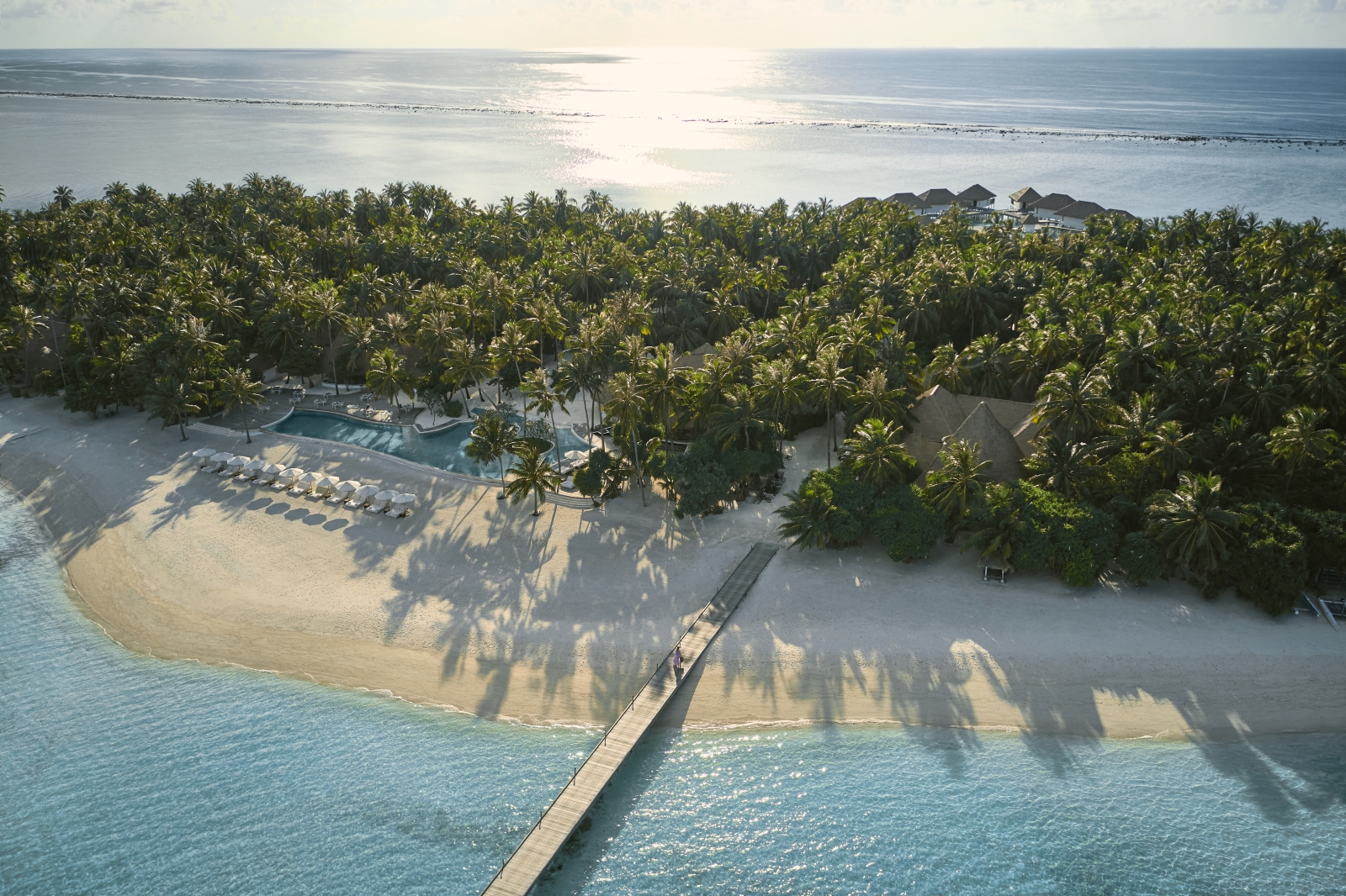 Aerial view of the beach and main pool at luxury resort COMO Maalifushi in the Maldives