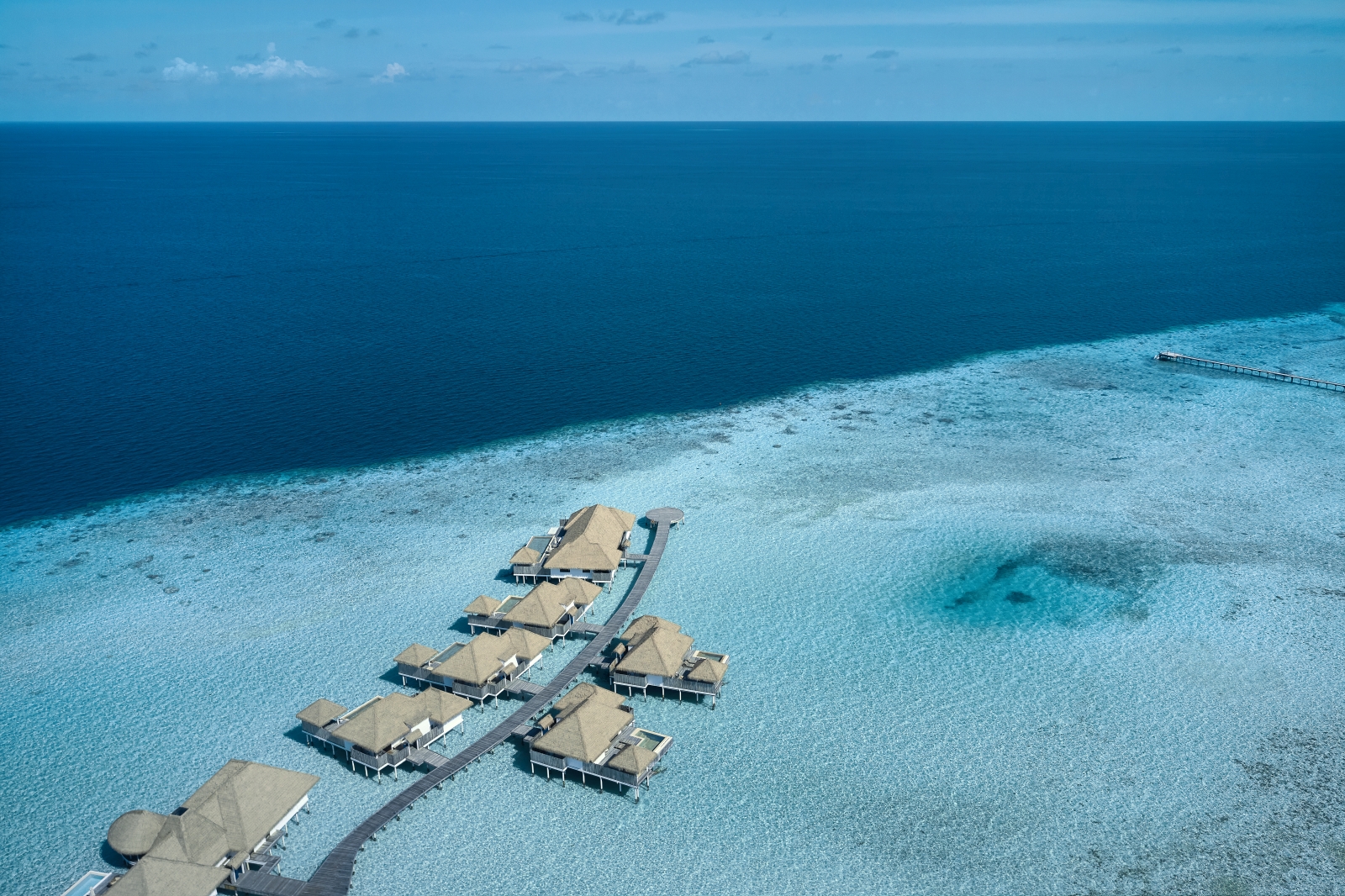 Aerial view over Water Villas at luxury resort COMO Maalifushi in the Maldives