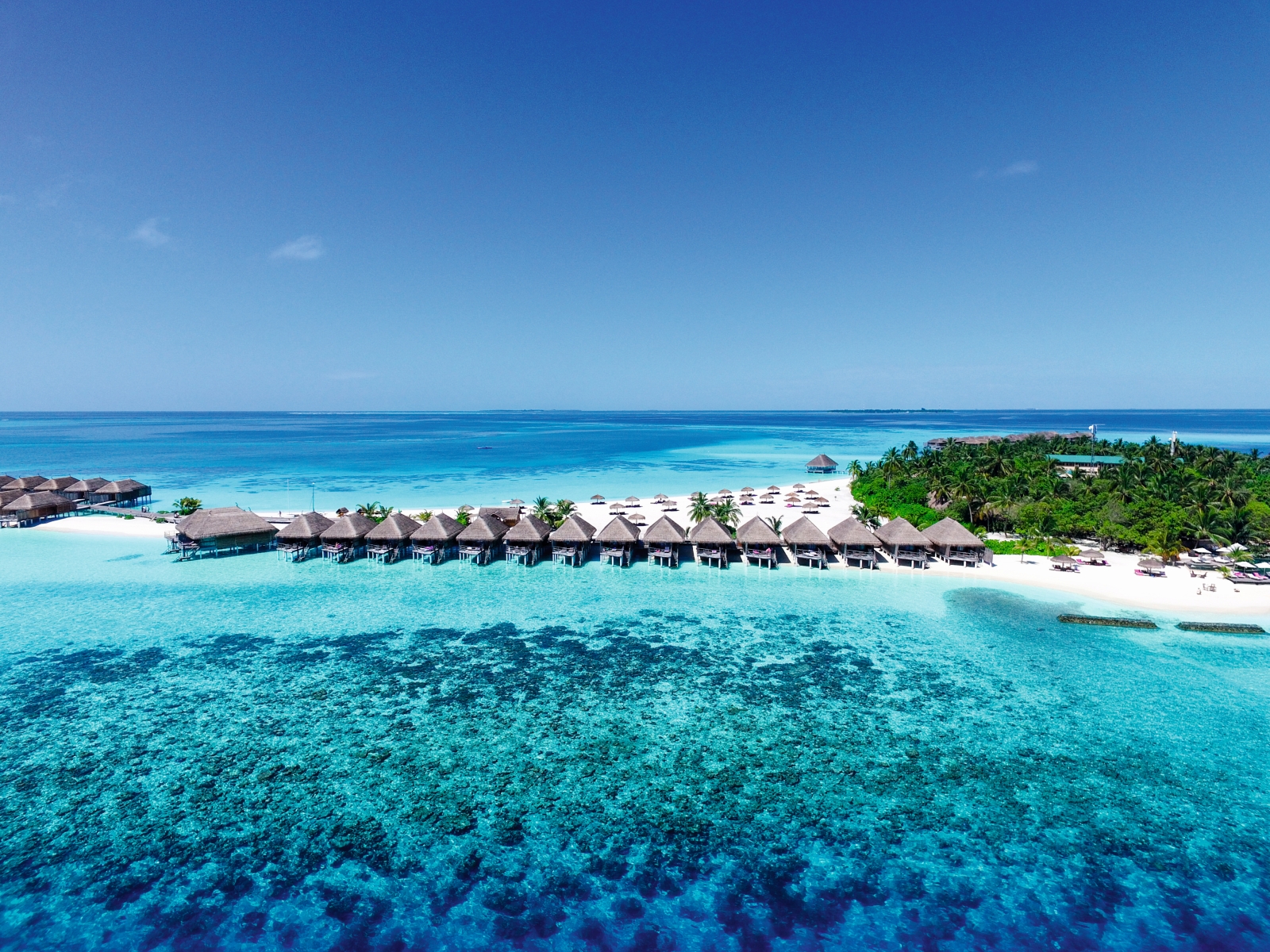 Aerial view of overwater villas at luxury resort Constance Moofushi in the Maldives