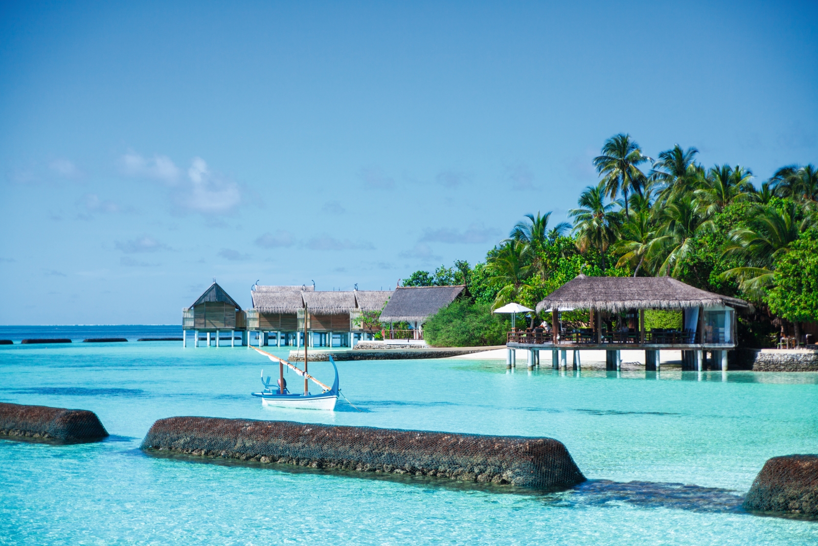 Seaside bar at luxury resort Constance Moofushi in the Maldives seen from the turquoise waters of the Indian Ocean