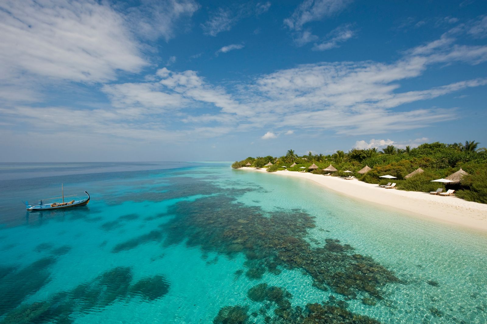 Traditional wooden boat off the shore of the Four Seasons Landaa Giraavaru in the Maldives