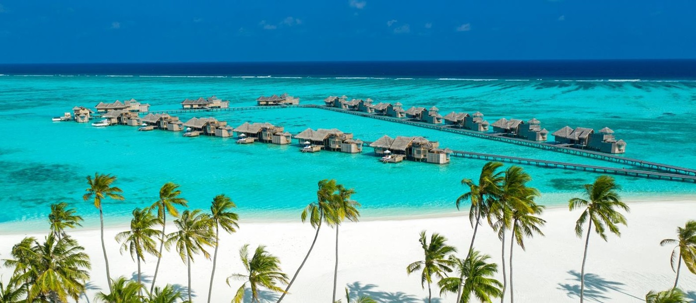 Aerial view of the beach, ocean and jetty with overwater villas at luxury resort Gili Lankanfushi in the Maldives