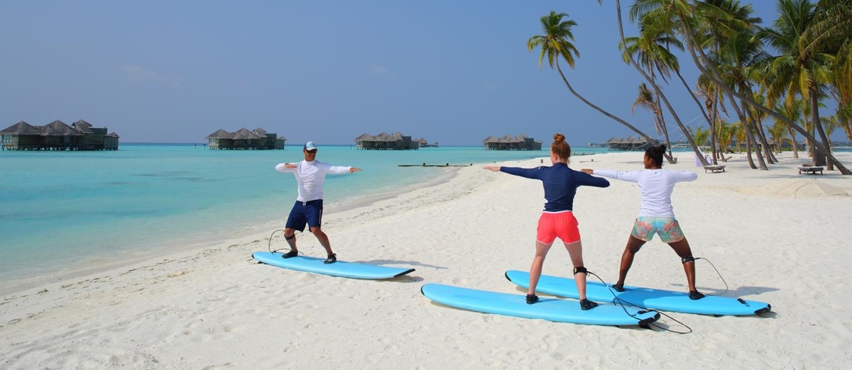 Surfing lesson on the beach of luxury resort Gili Lankanfushi in the Maldives