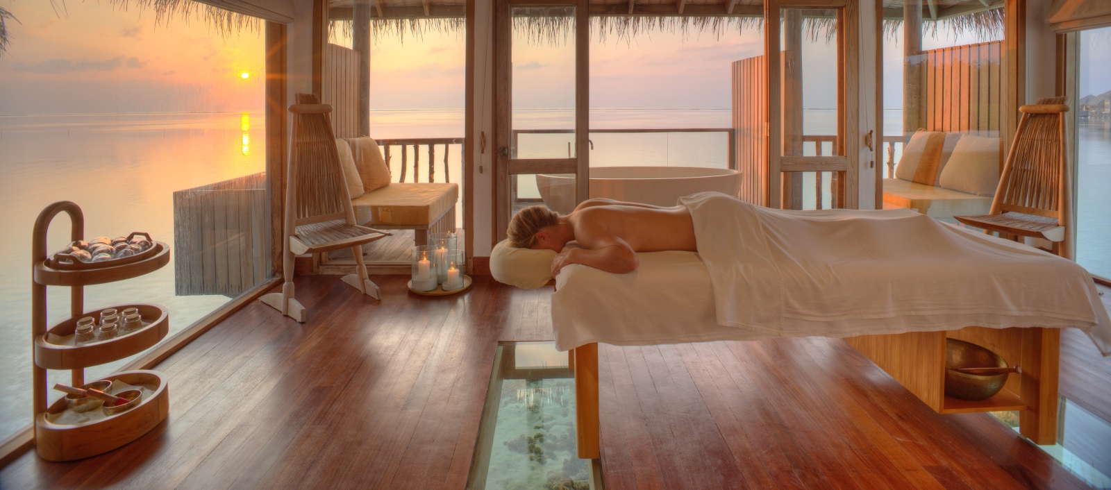 Spa treatment room overlooking the ocean at sunset at luxury resort Gili Lankanfushi in the Maldives