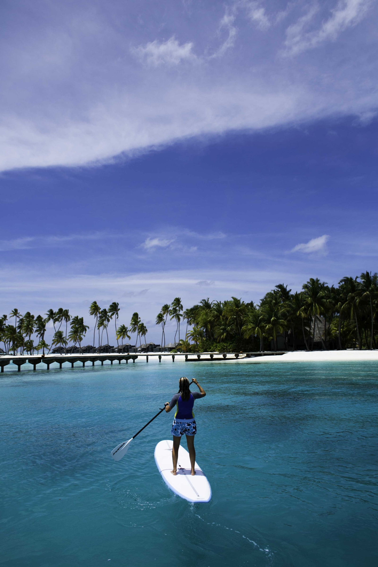 Guest paddleboarding at luxury resort Gili Lankanfushi in the Maldives