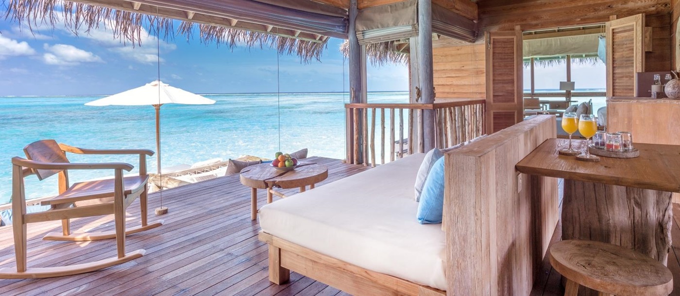 Living Room with seating and dining area and views over the Indian Ocean at luxury resort Gili Lankanfushi in the Maldives