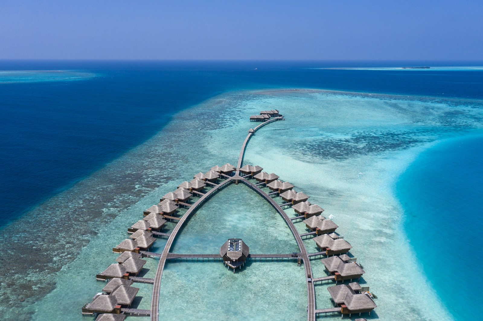 Aerial view over Overwater Bungalows at luxury resort Huvafen Fushi in the Maldives