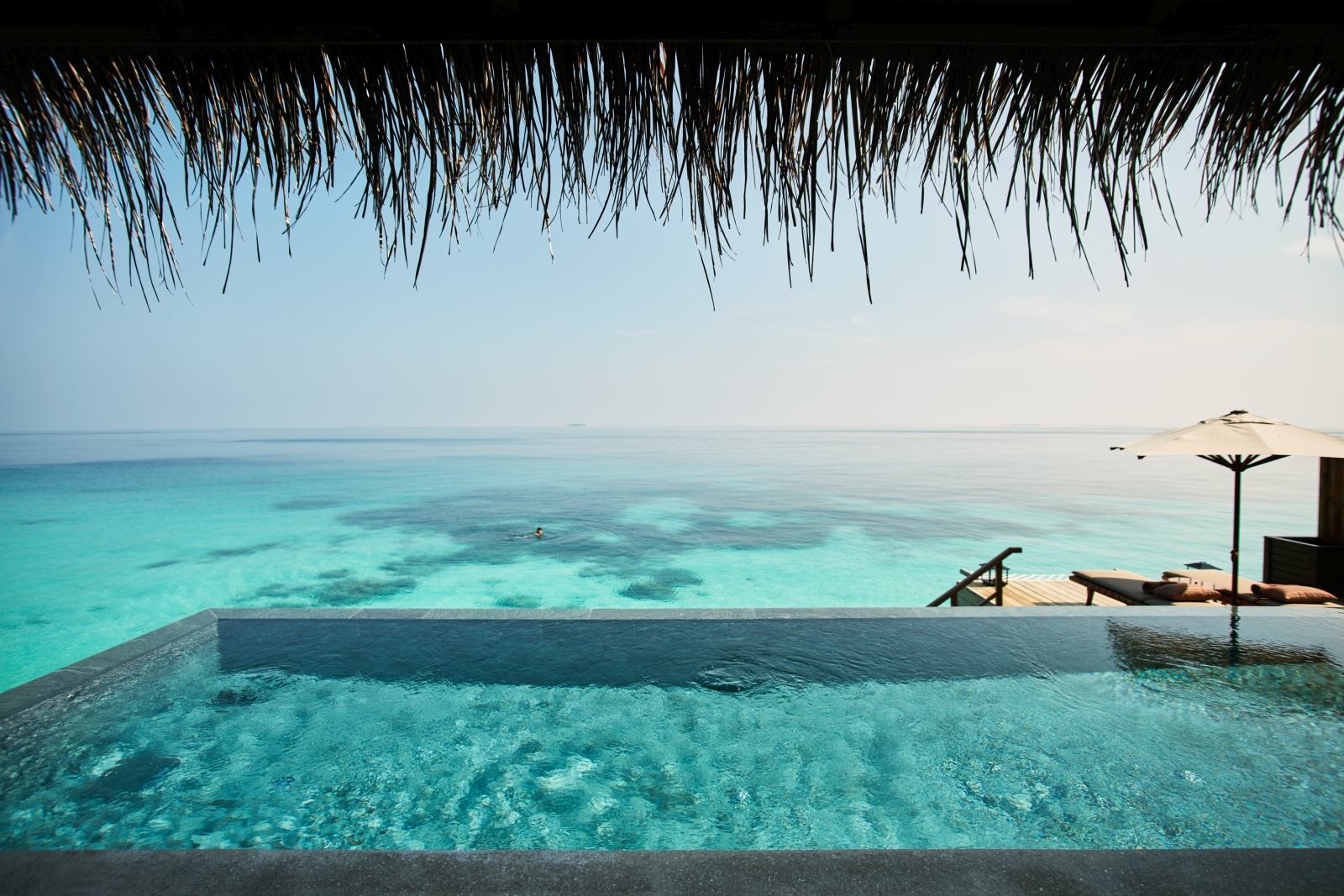 A view out to the Indian Ocean from a Water Villa including a view of the pool
