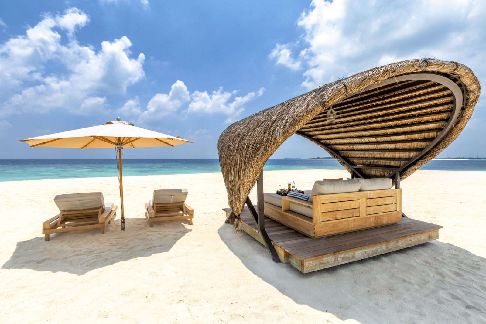 Two sunloungers and a beach cabana at luxury resort Kudadoo Private Island in the Maldives