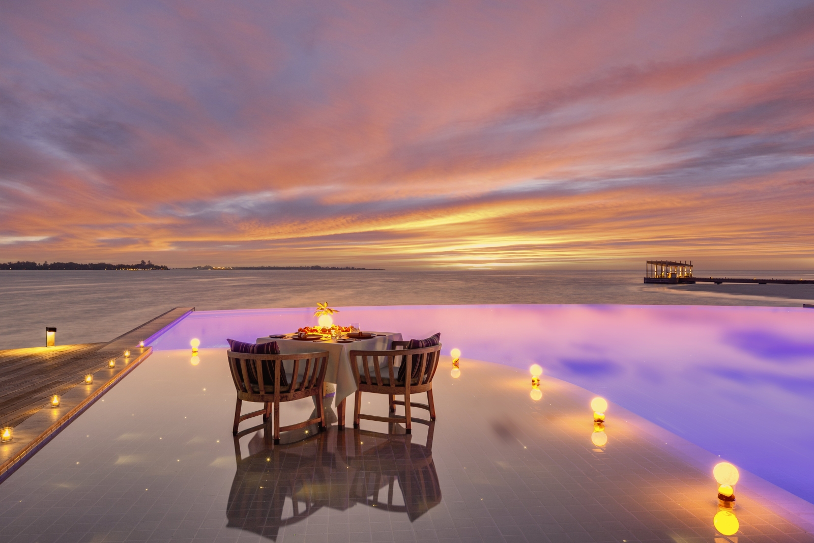 Romantic destination dining by the pool at luxury resort Kudadoo Private Island in the Maldives