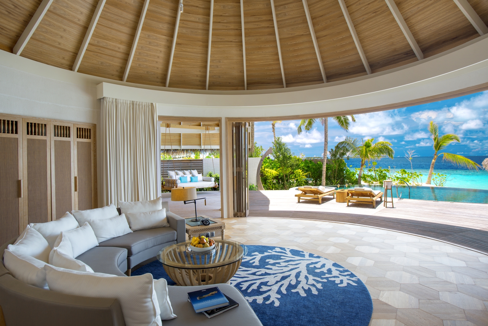 View from the living area of a Beach Residence luxury resort Milaidhoo in the Maldives over pool and Indian Ocean 