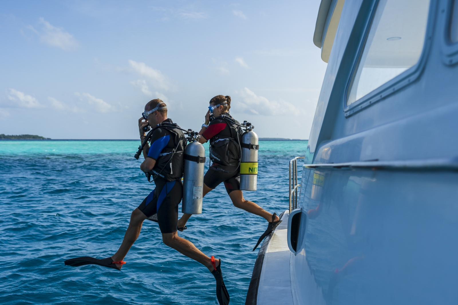 Two guests going scuba diving in the Indian Ocean at luxury resort Milaidhoo in the Maldives
