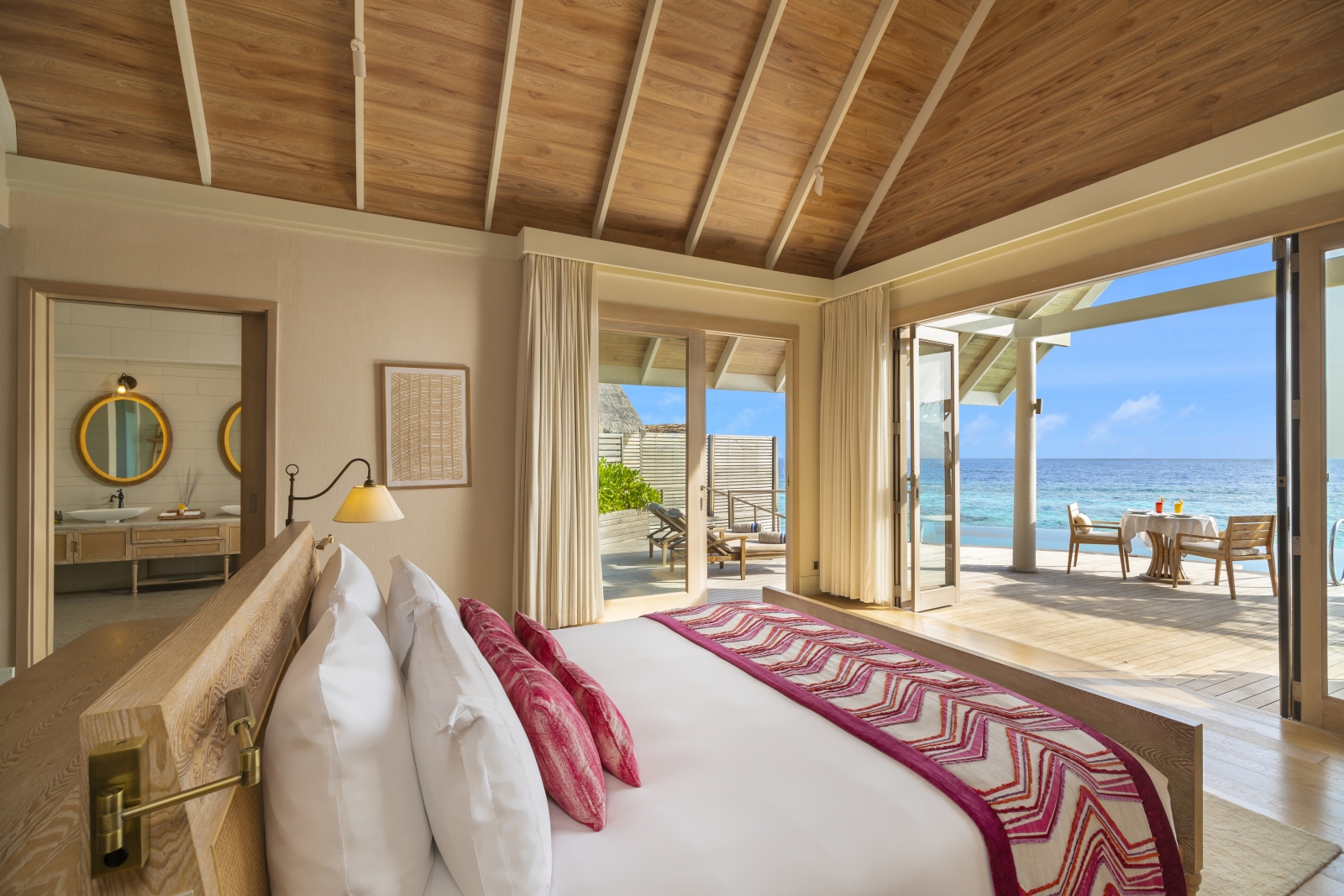 Bedroom of a Water Pool Villa at luxury resort Milaidhoo in the Maldives overlooking the private terrace and the Indian Ocean