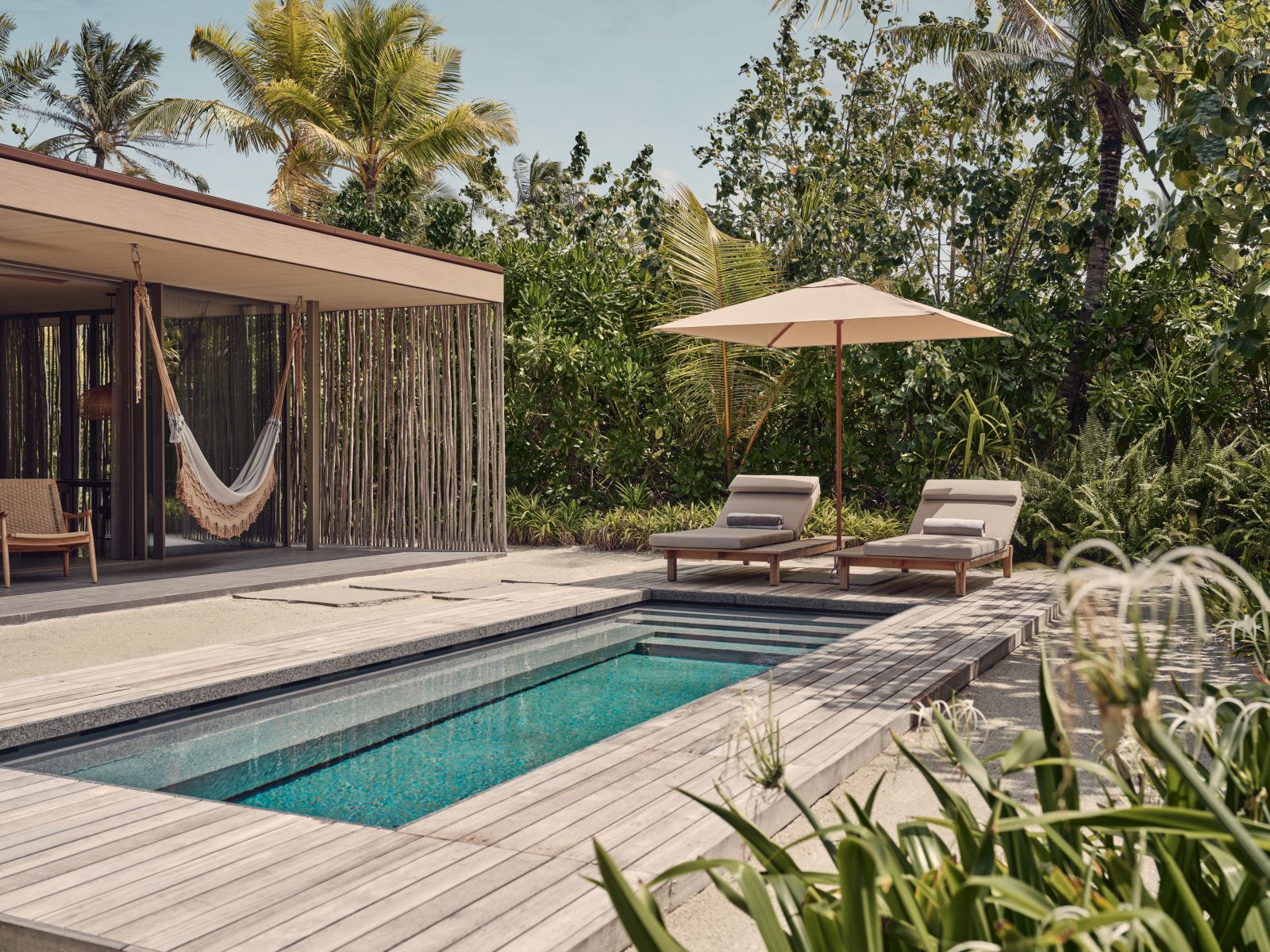 Private deck with pool of a beach villa at luxury resort Patina in the Maldives
