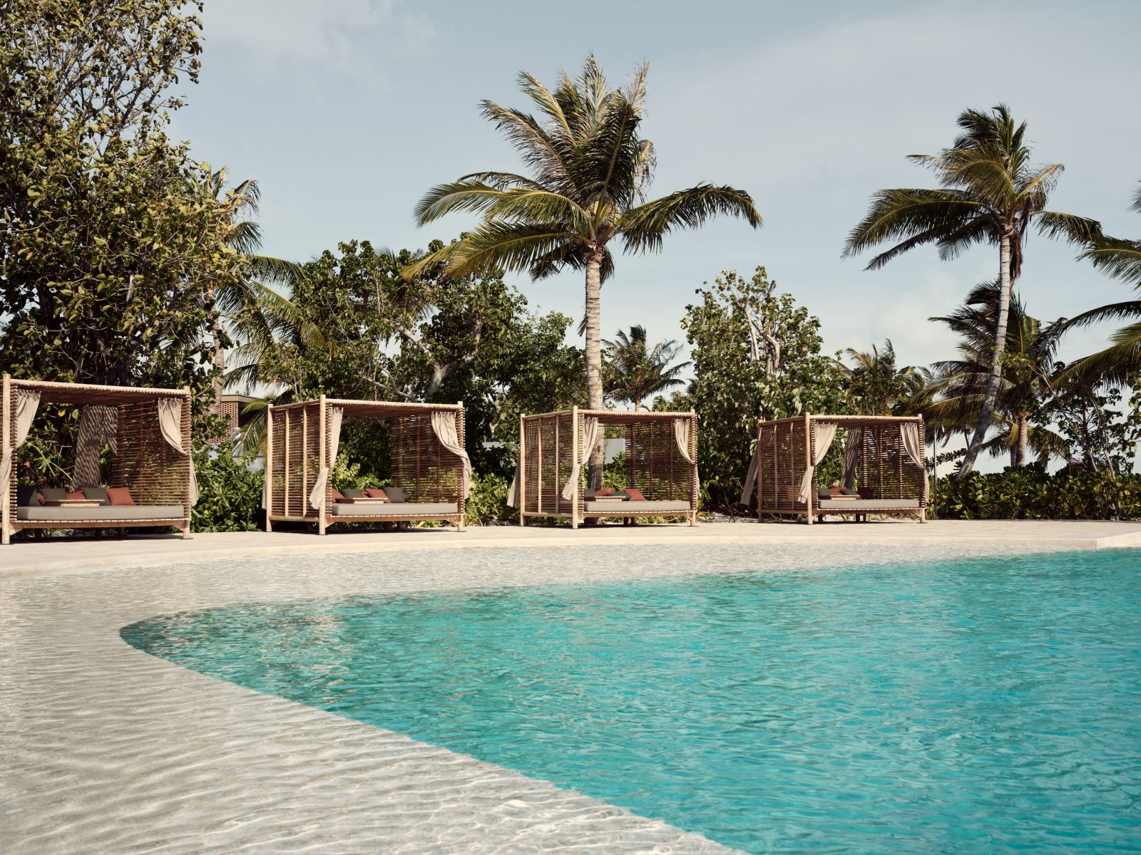 Cabana-lined pool at Fari Beach Club at luxury resort Patina in the Maldives