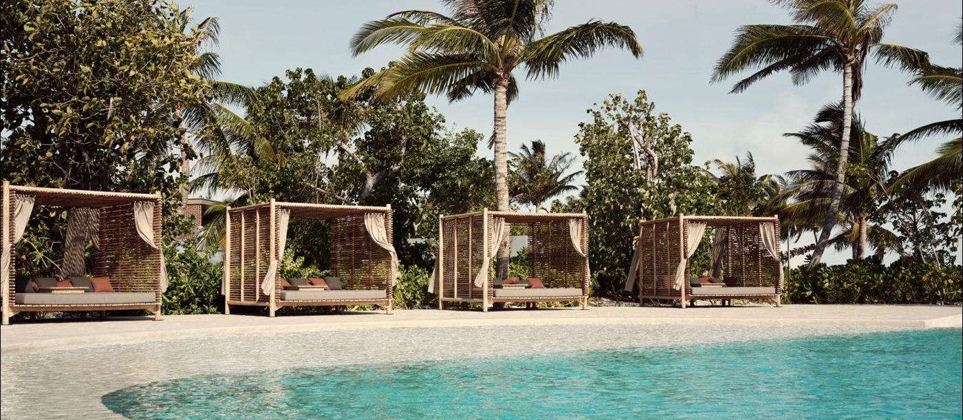 Cabana-lined pool at Fari Beach Club at luxury resort Patina in the Maldives