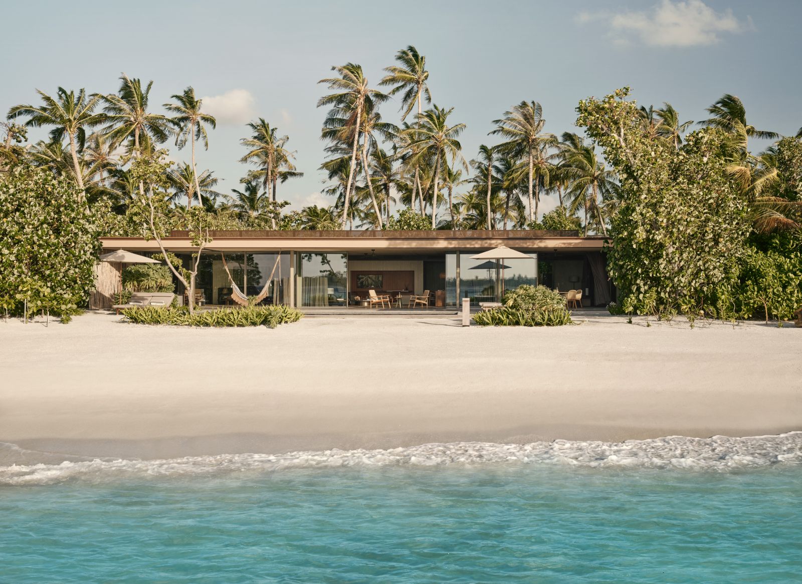 Exterior of a sunset beach villa at luxury resort Patina in the Maldives