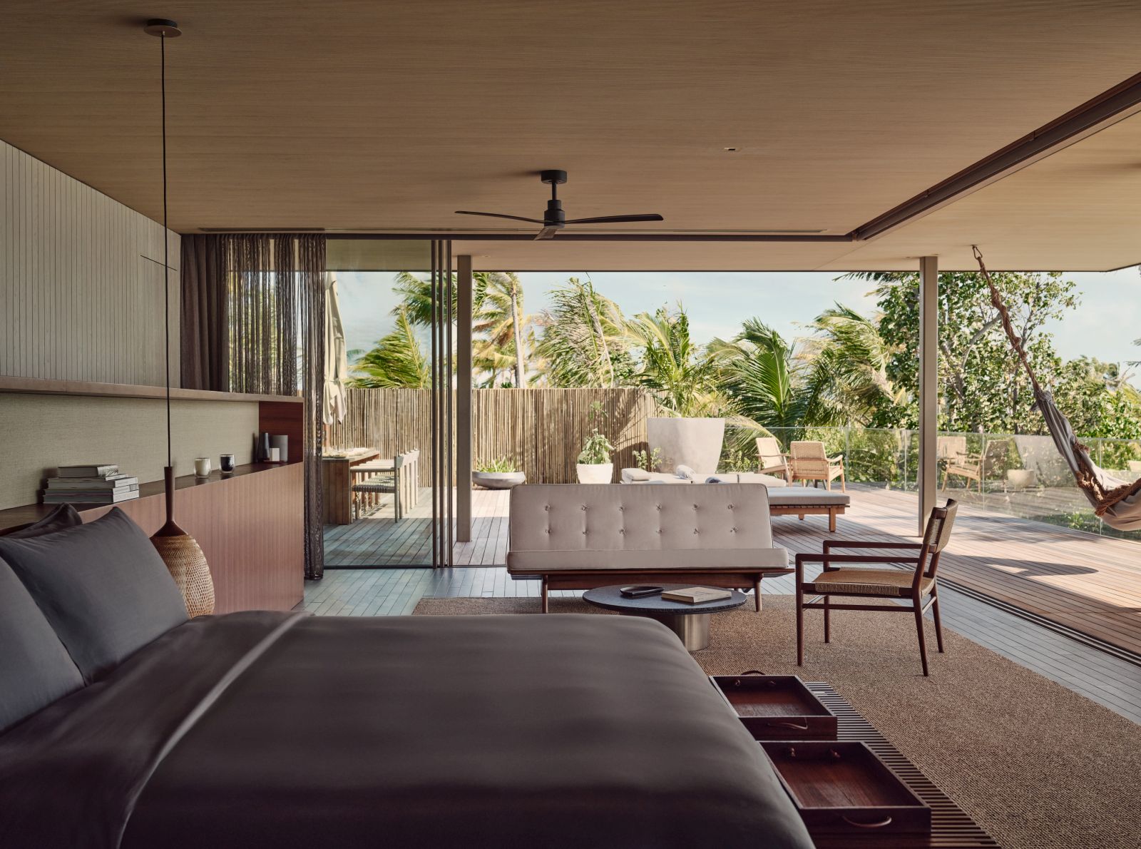 Extensive bedroom with sliding walls opening to the private deck of The Beach House at luxury resort Patina in the Maldives