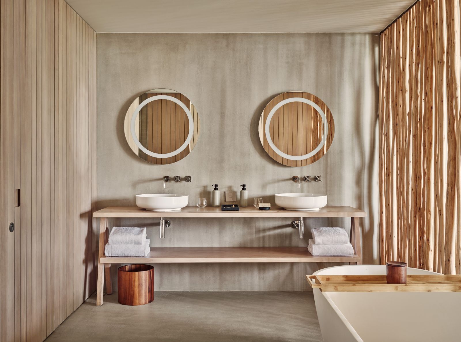 Bright bathroom with light wooden features, double vanity and tub at Villa Fari at the luxury resort Patina in the Maldives